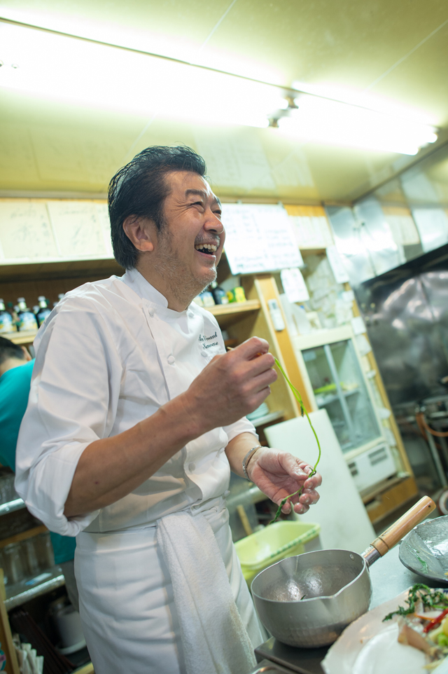 漁師さんのトークに笑いながら料理をする河瀬シェフ