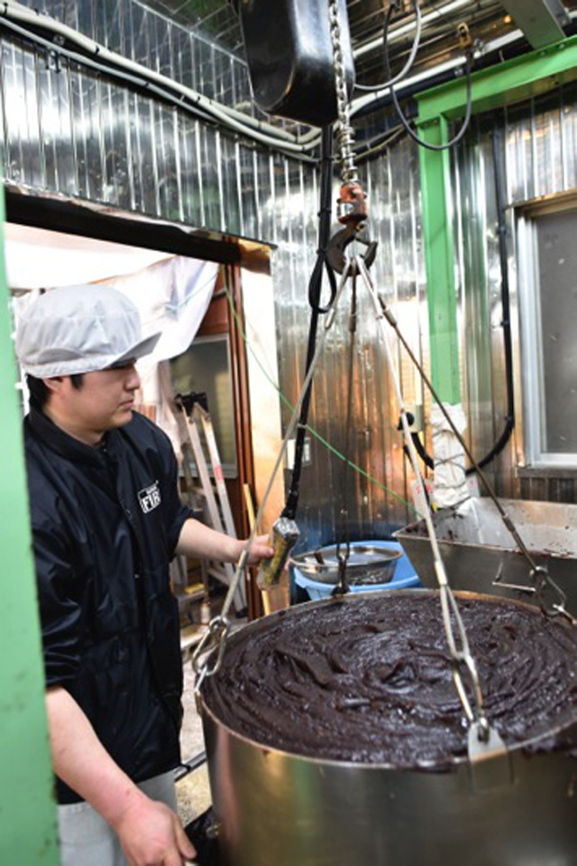 bronze pot being lifted with a hoist